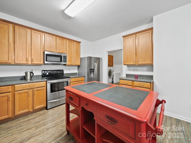 2306 Nettleton Ct, Matthews, NC 28105 - kitchen featuring stainless steel appliances, dark countertops, light wood finished floors, washer / clothes dryer, and open shelves