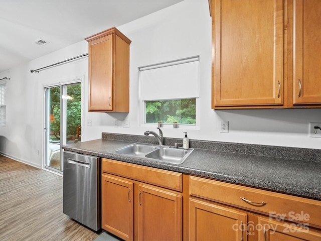 2306 Nettleton Ct, Matthews, NC 28105 - kitchen with stainless steel dishwasher, a sink, light wood-style flooring, dark countertops, and brown cabinetry