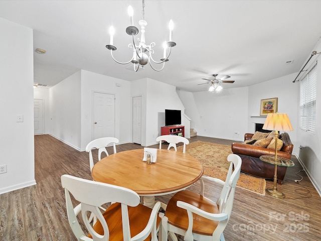 2306 Nettleton Ct, Matthews, NC 28105 - dining area with ceiling fan, wood finished floors, baseboards, a fireplace, and a chandelier