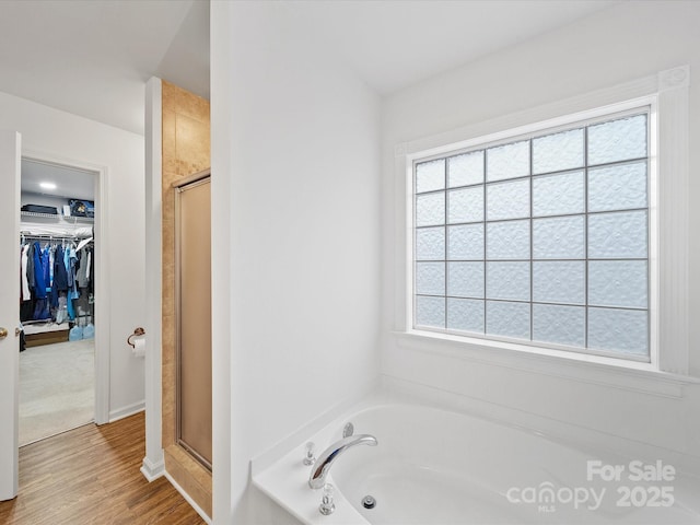 2306 Nettleton Ct, Matthews, NC 28105 - bathroom with a shower stall, a spacious closet, a garden tub, and wood finished floors