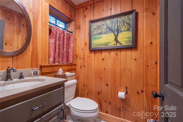 973 Sitting Rock Trl, Cullowhee, NC 28723 - bathroom featuring toilet, vanity, and wood walls