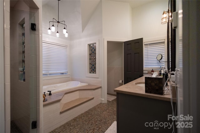 973 Sitting Rock Trl, Cullowhee, NC 28723 - full bath featuring double vanity, a bath, a shower stall, tile patterned flooring, and a chandelier