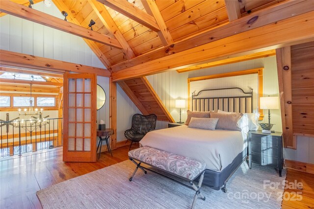 973 Sitting Rock Trl, Cullowhee, NC 28723 - bedroom featuring wood finished floors, a chandelier, wooden walls, wood ceiling, and french doors