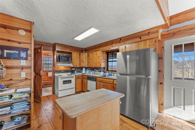 178 Tablerock Dr, Saluda, NC 28773 - kitchen with freestanding refrigerator, white electric range, black microwave, dishwasher, and light wood-style floors