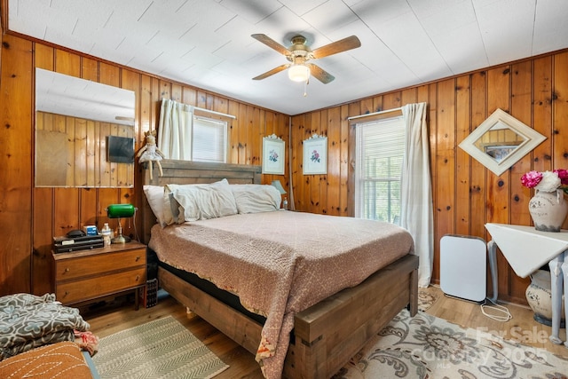 715 Broadway St NW, Lenoir, NC 28645 - bedroom featuring multiple windows, light wood-style floors, wood walls, and ceiling fan