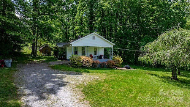 715 Broadway St NW, Lenoir, NC 28645 - bungalow featuring a porch, driveway, a front yard, and a view of trees