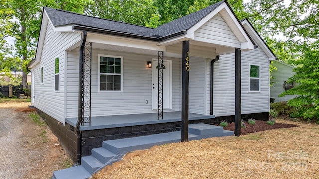 view of front facade with a porch and a shingled roof