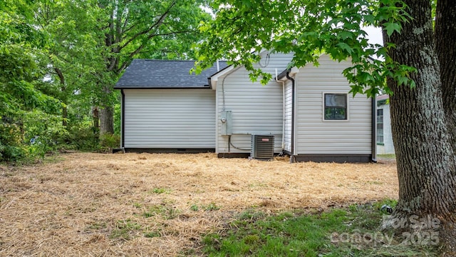 back of house with roof with shingles, central AC, and crawl space
