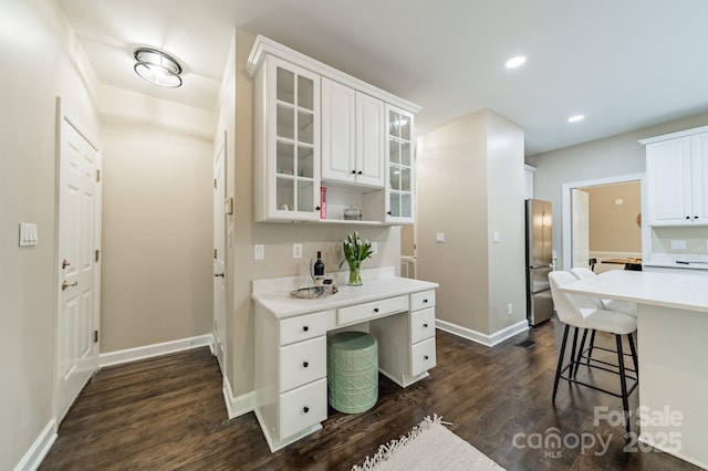 2907 Notchview Ct, Charlotte, NC 28210 - kitchen with dark wood-type flooring, white cabinets, light countertops, glass insert cabinets, and baseboards