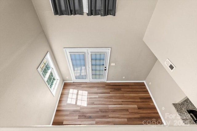 8610 Sawleaf Ct, Charlotte, NC 28215 - unfurnished living room featuring wood finished floors, baseboards, and a high ceiling