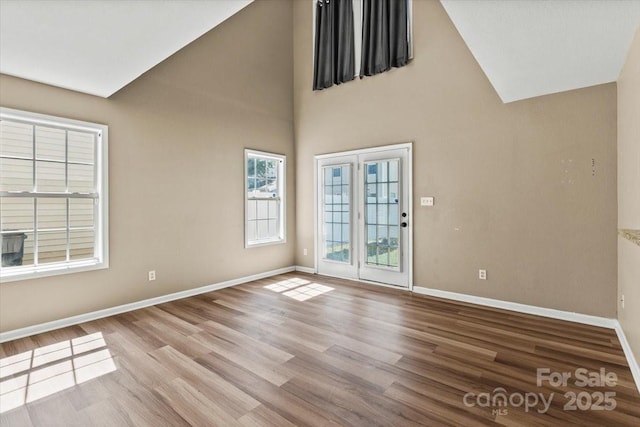 8610 Sawleaf Ct, Charlotte, NC 28215 - unfurnished room featuring baseboards, wood finished floors, and high vaulted ceiling