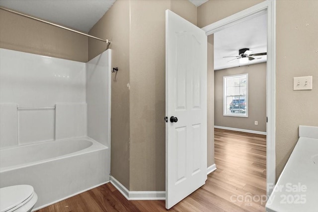 8610 Sawleaf Ct, Charlotte, NC 28215 - bathroom with wood finished floors, toilet, ceiling fan, shower / tub combination, and baseboards