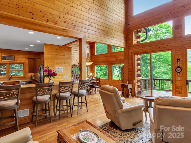 421 Ramp Patch Ln, Waynesville, NC 28786 - living room featuring a towering ceiling, wooden walls, light wood-type flooring, and recessed lighting