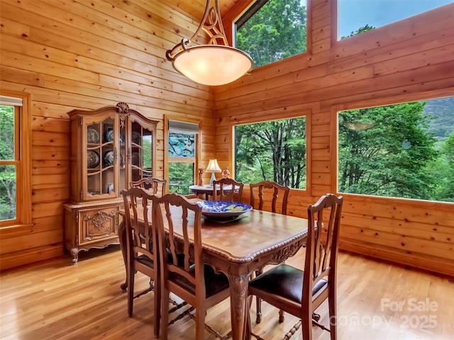 421 Ramp Patch Ln, Waynesville, NC 28786 - dining space with wood walls, a towering ceiling, and light wood-style floors