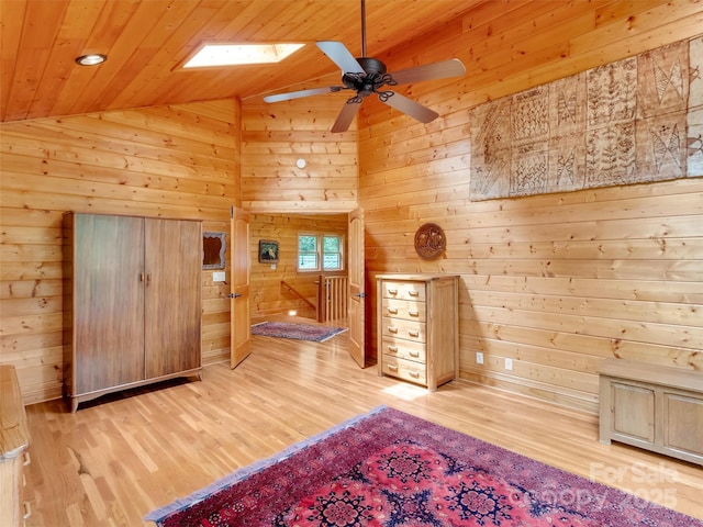 421 Ramp Patch Ln, Waynesville, NC 28786 - unfurnished bedroom featuring lofted ceiling, light wood-style flooring, wood walls, a skylight, and wooden ceiling