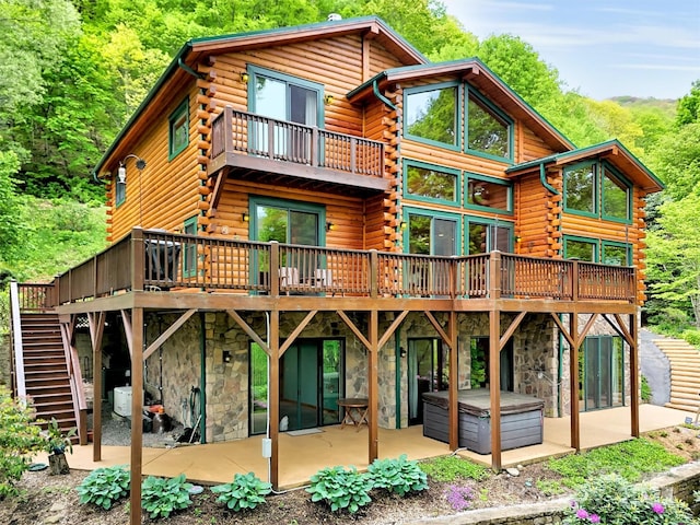 421 Ramp Patch Ln, Waynesville, NC 28786 - back of property with log siding, a patio, stone siding, and a hot tub