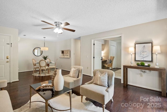 living room featuring wood finished floors, ceiling fan, a textured ceiling, and baseboards