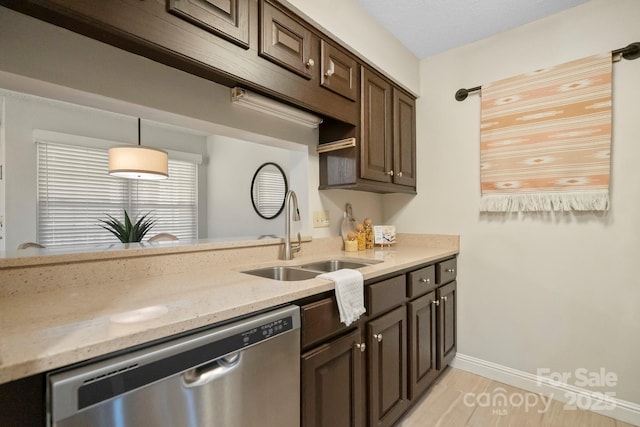kitchen with dishwasher, a sink, dark brown cabinetry, light stone countertops, and decorative light fixtures