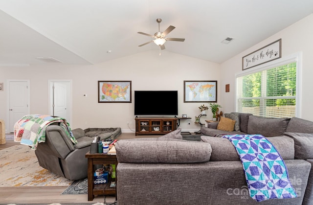 living area with wood finished floors, a ceiling fan, and lofted ceiling