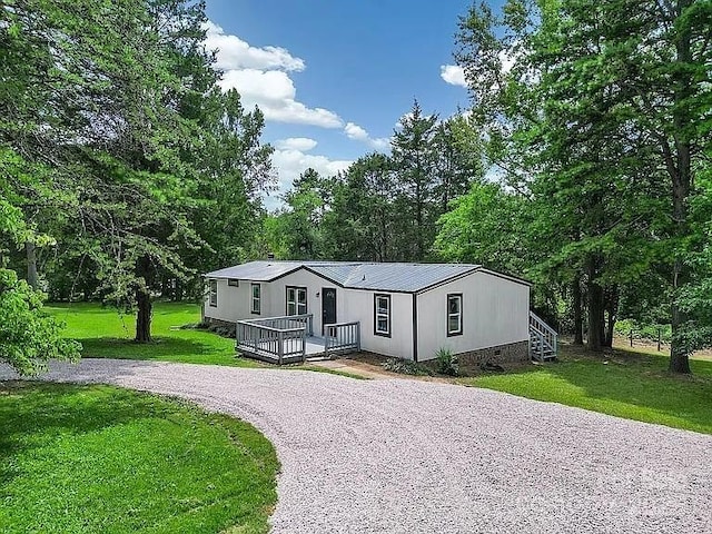 10379 Turnplow Dr, Davidson, NC 28036 - manufactured / mobile home with driveway, a deck, a front yard, and metal roof