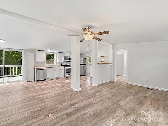 10379 Turnplow Dr, Davidson, NC 28036 - unfurnished living room with light wood-style flooring, ceiling fan, baseboards, and a sink