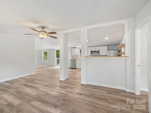 10379 Turnplow Dr, Davidson, NC 28036 - unfurnished living room with ceiling fan, wood finished floors, and baseboards
