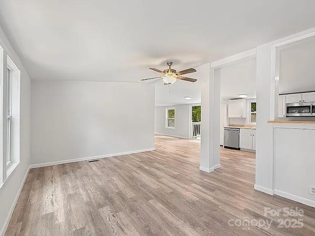10379 Turnplow Dr, Davidson, NC 28036 - unfurnished living room featuring light wood-style flooring, ceiling fan, and baseboards