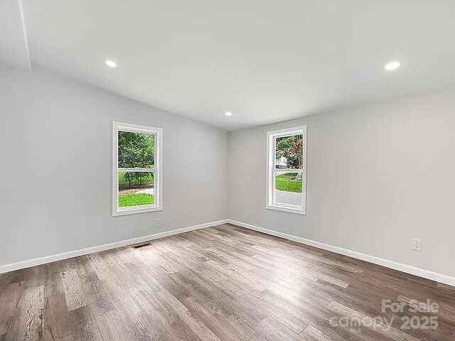 10379 Turnplow Dr, Davidson, NC 28036 - empty room featuring healthy amount of natural light, wood finished floors, baseboards, recessed lighting, and lofted ceiling