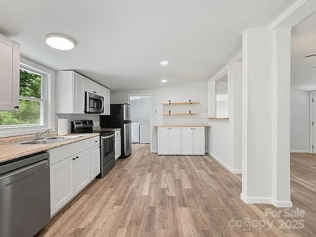10379 Turnplow Dr, Davidson, NC 28036 - kitchen with appliances with stainless steel finishes, washer and dryer, light wood finished floors, a sink, and white cabinets