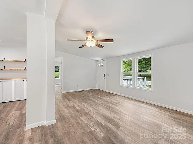 10379 Turnplow Dr, Davidson, NC 28036 - unfurnished living room with ceiling fan, light wood-style flooring, baseboards, and vaulted ceiling