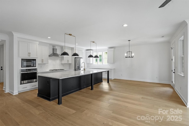 13618 Tranquil Day Dr, Matthews, NC 28105 - kitchen featuring stainless steel appliances, wall chimney exhaust hood, light countertops, white cabinets, and light wood-style flooring