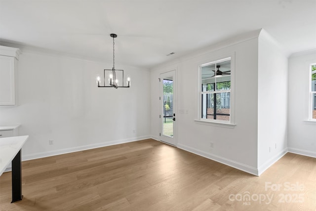13618 Tranquil Day Dr, Matthews, NC 28105 - unfurnished dining area featuring light wood-style flooring, ornamental molding, healthy amount of natural light, a chandelier, and baseboards