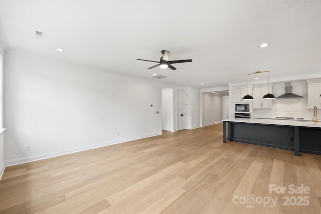 13618 Tranquil Day Dr, Matthews, NC 28105 - unfurnished living room with a ceiling fan, recessed lighting, light wood-style floors, and baseboards