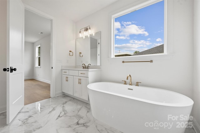 13618 Tranquil Day Dr, Matthews, NC 28105 - bathroom featuring a freestanding tub, vanity, marble finish flooring, and baseboards