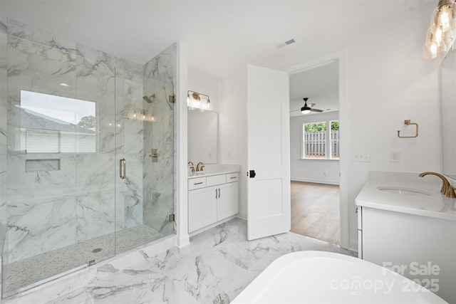 13618 Tranquil Day Dr, Matthews, NC 28105 - bathroom with two vanities, a marble finish shower, a soaking tub, marble finish floors, and a ceiling fan