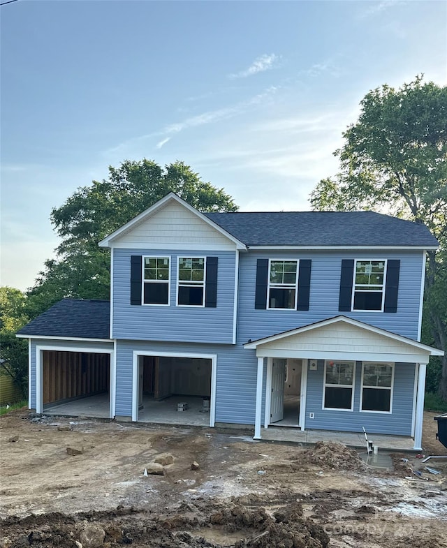 view of front of house featuring driveway, roof with shingles, and an attached garage