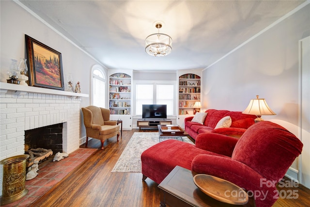 501 Pee Dee Ave, Albemarle, NC 28001 - living area featuring dark wood-style floors, a fireplace, a chandelier, built in shelves, and ornamental molding