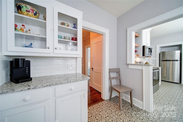 501 Pee Dee Ave, Albemarle, NC 28001 - kitchen with stainless steel appliances, white cabinetry, glass insert cabinets, and tasteful backsplash