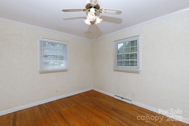 empty room featuring a baseboard heating unit, wood finished floors, baseboards, a ceiling fan, and crown molding