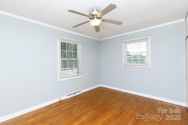 spare room with baseboards, wood finished floors, crown molding, and ceiling fan