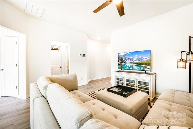 living room with wood finished floors, ceiling fan, and baseboards