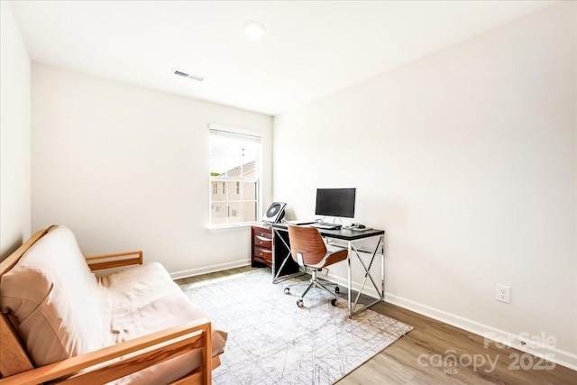 home office with baseboards and light wood-style flooring