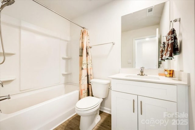full bathroom featuring toilet, shower / bathtub combination with curtain, vanity, wood finished floors, and baseboards