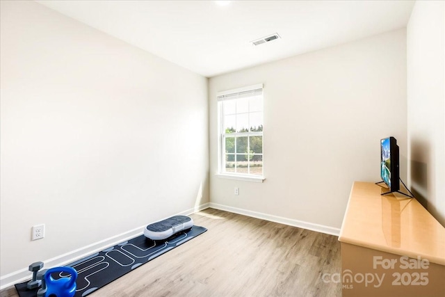 workout area featuring wood finished floors and baseboards