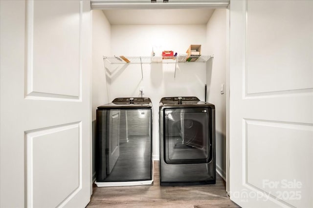laundry room featuring washing machine and clothes dryer and wood finished floors