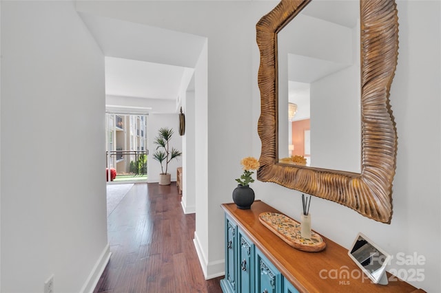 corridor with baseboards and dark wood-style flooring