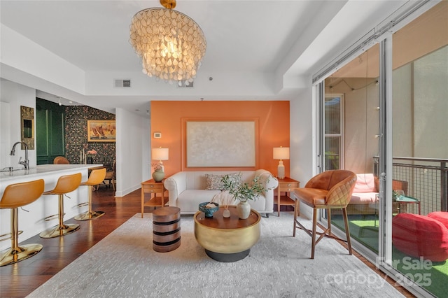 living area featuring wood finished floors, baseboards, and a chandelier