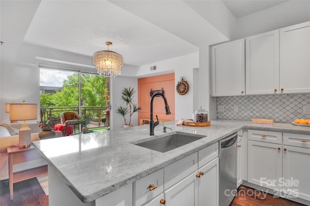 kitchen with a sink, a peninsula, dishwasher, and white cabinets