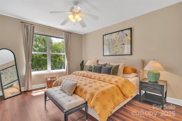 bedroom featuring baseboards, wood finished floors, and a ceiling fan