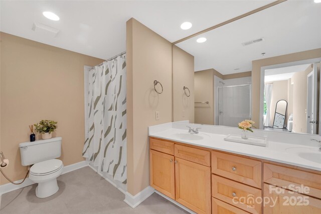 full bathroom featuring a shower with curtain, toilet, double vanity, and baseboards